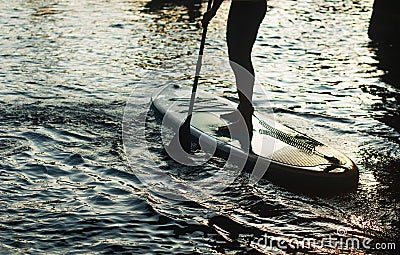 Stand up paddle surfing silhouette. a man stands with a paddle on a Board closeup, Stock Photo