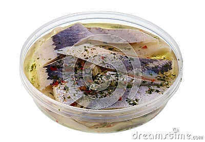 The standard round plastic container with marinated salty fillet of Norwegian herring fish with spices isolated macro Stock Photo