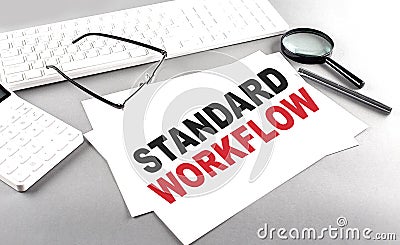 STANDARD WORKFLOW text on a paper with keyboard, calculator on grey background Stock Photo