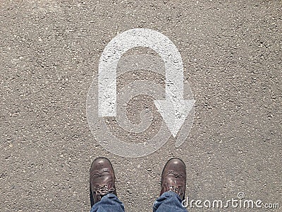 Standing on the asphalt concrete floor in front of u turn symbol Stock Photo