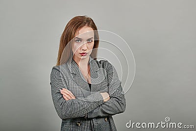 Standing and cross arms on chest. Young attractive woman, dressed gray jacket Stock Photo