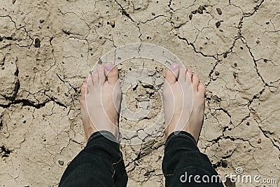 Standing feet on cracked ground Stock Photo