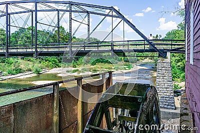 Standing on the historic War Eagle Bridge in Rogers, Arkansas one can see the working water wheel powered by the War Eagle River Stock Photo