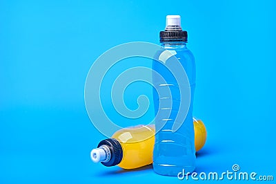 Standing and lying isotonic energy orange yellow and blue sport drink in plastic bottles on blue background Stock Photo