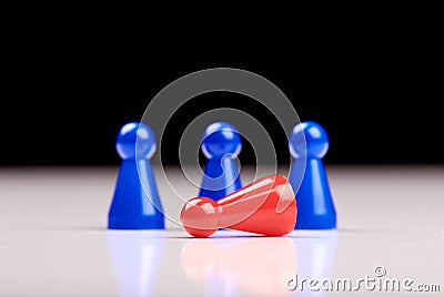 Standing three blue game pieces as winner and lying red figurine as loser on white table top with black background - Space for Stock Photo