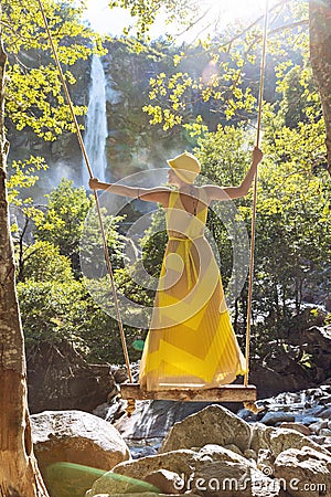 Standing woman dangles on a swing Stock Photo