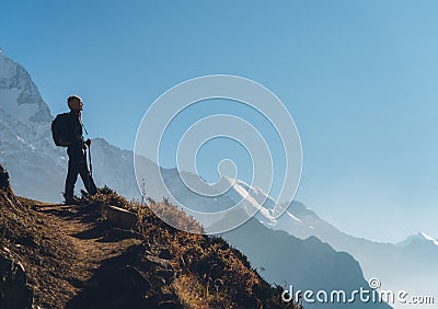 Standing young woman on the hill and looking on mountains Stock Photo