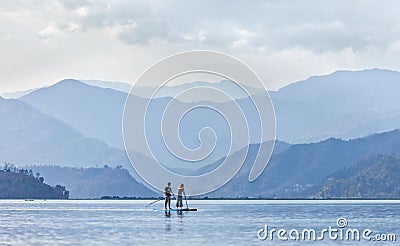Standup paddleboarding on the Pheva lake in Himalaya Editorial Stock Photo