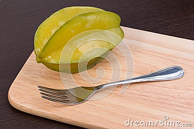 Star apple and fork on wooden block. Fresh star apple fruit and fork on wood table. Stock Photo