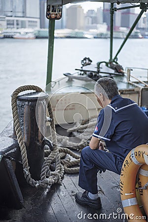 Star Ferry staff sits as the boat crosses Victoria Harbour in Hong Kong Editorial Stock Photo