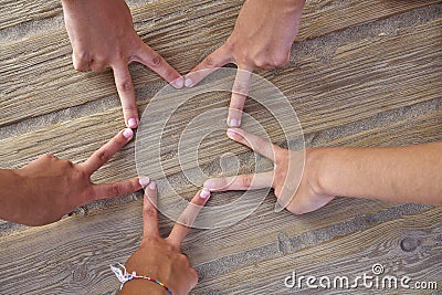 Star shape with six hand fingers on a beach Stock Photo