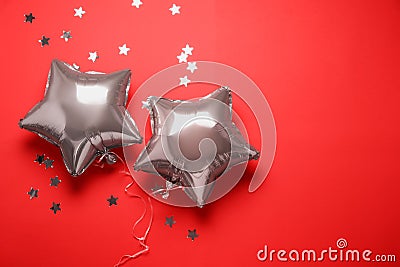 Star shaped pink balloons and confetti on red background, flat lay Stock Photo