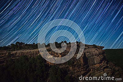 Star trail above rock cliff Stock Photo