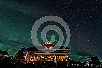 Star Trails and Aurora - Long exposure to capture star trails and light aurora borealis over Swedish countryside house, night Cartoon Illustration