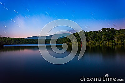 Star trails over Julian Price Lake at night, along the Blue Ridge Parkway in North Carolina. Stock Photo