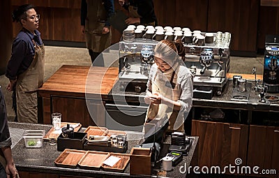 A Starbucks barista making coffee for their customer at the Starbucks Reserve Roastery in Shanghai Editorial Stock Photo