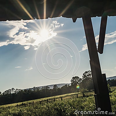 Starburst Sun Under the Eve of an Open Air Barn Stock Photo