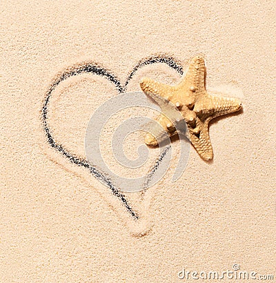 Starfish and heart drawn on sand Stock Photo