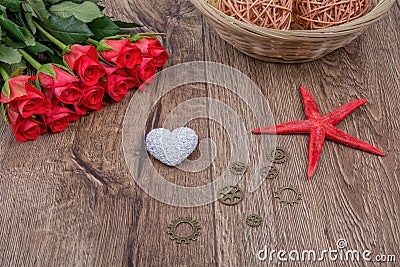 Starfish, heart and red roses on a wooden background Stock Photo