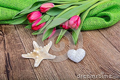 Starfish, heart and tulips on a wooden table Stock Photo