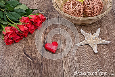 Starfish, heart and roses on a wooden background Stock Photo