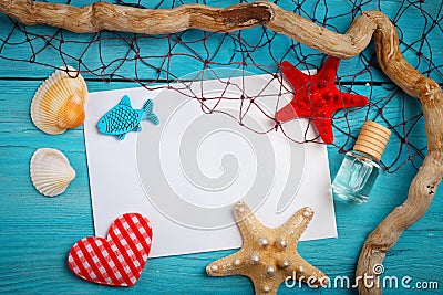Starfish, pebbles and shells lying on a blue wooden background with postcard. There is a place for labels. Stock Photo
