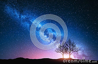 Starry sky with pink Milky Way and trees Stock Photo