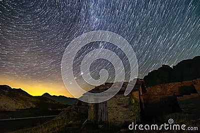 Stars trails and isolated house in switzerland alps Stock Photo