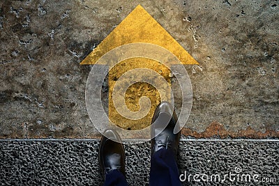 Start and Challenge Concept. a Business Man on Formal Shoes Steps to Follow a Yellow Arrow, Get Ready to Moving Forward or take a Stock Photo