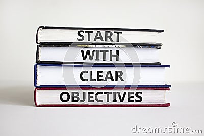 Start with clear objectives symbol. Books with words `Start with clear objectives`. Businessman hand. Beautiful white background Stock Photo