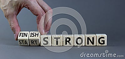 Start and finish strong symbol. Businessman turns wooden cubes, changes words `start strong` to `finish strong`. Beautiful gre Stock Photo
