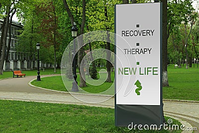 Start to live without alcohol addiction. Advertising board with inscription RECOVERY, THERAPY AND NEW LIFE in park Stock Photo