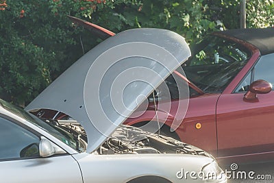 Gardener mowing the grass of an embankment in a town with a battery lawn trimmer, GermanyStarting aid in the event of a car breakd Stock Photo