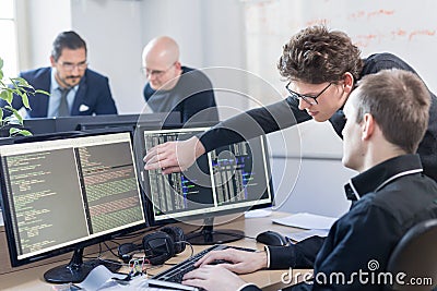 Startup business problem solving. Software developers working on desktop computer. Stock Photo