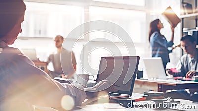 Startup team at work. Big open space office, laptops and paperwork. Business concept Stock Photo