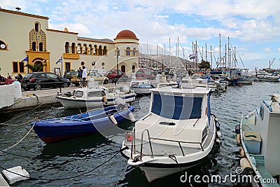 State building and some traditional fishing boat in front by the harbour in Calymnos Island Editorial Stock Photo