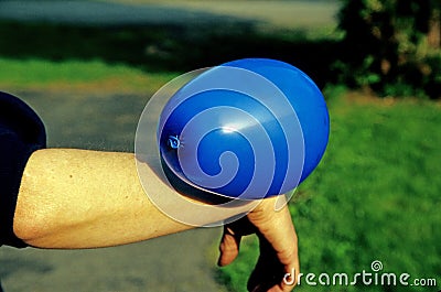 Static electricity shown by balloon attached to female arm Stock Photo