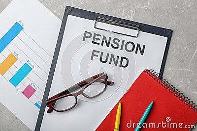 Stationery, glasses, notebook, chart and paper with words PENSION FUND on table Stock Photo