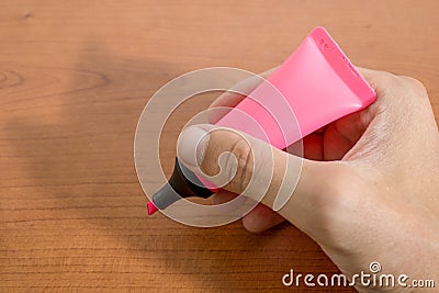 Stationery, a hand is holding a pink marker Stock Photo