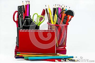 Stationery in two glasses, a red notebook, pencils isolated on a white background Stock Photo