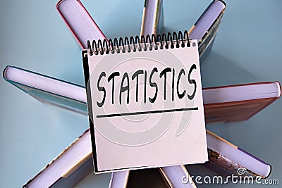 STATISTICS - word on a yellow piece of paper on the background of books Stock Photo