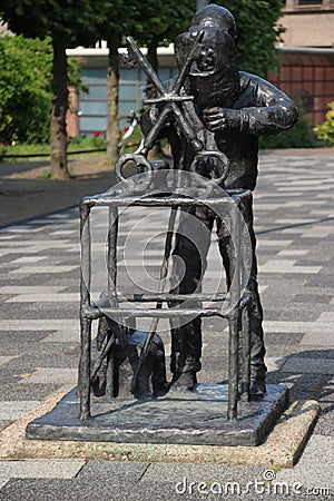 Statue of a blacksmith in cast iron, holding two keys, the coat of arms of the municipality of Waddinxveen in the Netherlands Editorial Stock Photo