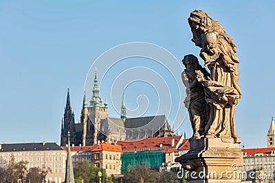 Statue on Charles Brigde against St. Vitus Cathedral in Prague Stock Photo