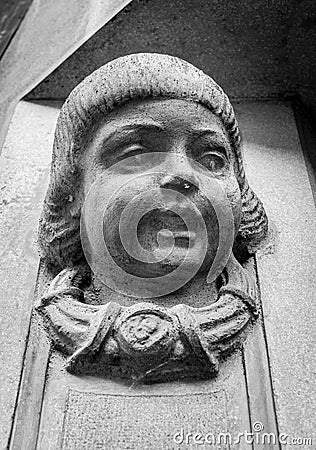 Statue of a child`s head on the entrance wall of an old building Stock Photo