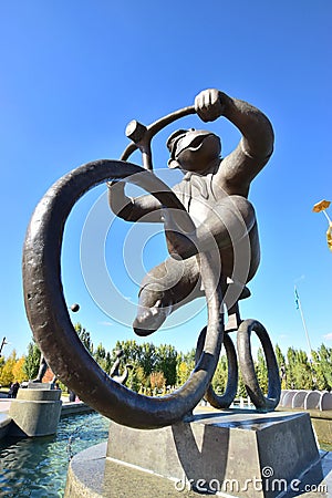 A statue featuring a monkey riding a circus bicycle Editorial Stock Photo