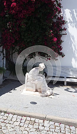 Statue of a fisherman reparing his net in Portugal Stock Photo