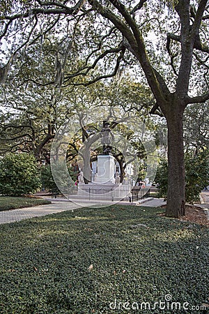 A statue of General James Edward Oglethorpe at Franklin Square with lush green weeping willow trees, plants and grass in Savannah Editorial Stock Photo