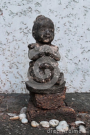 A statue of a girl standing over a pile of stones. Stock Photo