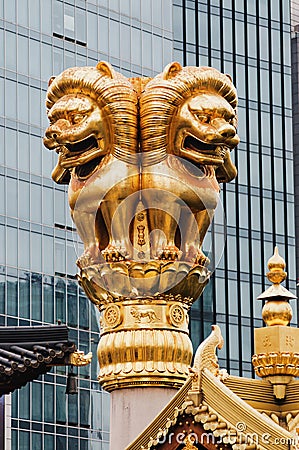Statue of a golden lion on the roof of a Buddhist temple against the backdrop of a modern building Editorial Stock Photo