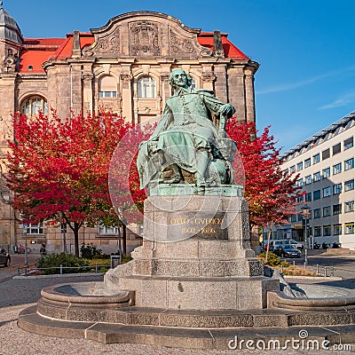 Statue of great scientist Otto von Guericke in red and golden Autumn colors in historical downtown of Magdeburg Germany, at sunny Editorial Stock Photo